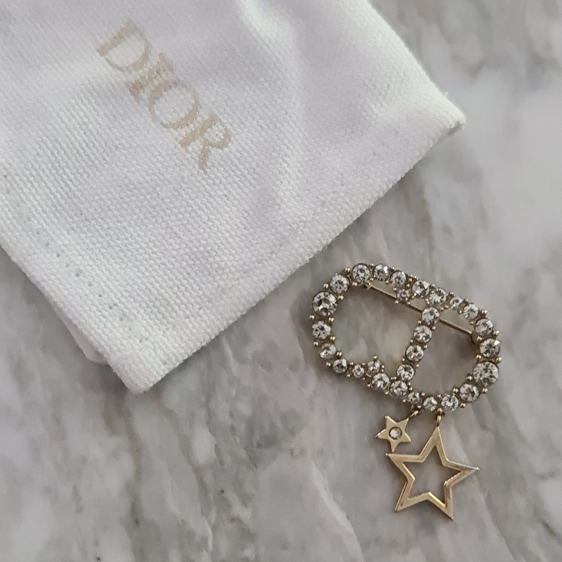 Broche Dior doré avec cristaux blancs